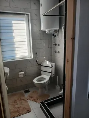 a small bathroom with a toilet and a window at Apartmani SARA Vranje in Vranje