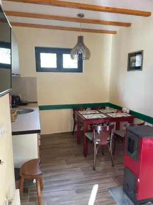 a kitchen and dining room with a table and chairs at Apartman Vuk, Crni Vrh - Stara planina in Crni Vrh