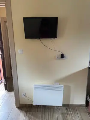 a flat screen tv on a wall with a radiator at Apartman Vuk, Crni Vrh - Stara planina in Crni Vrh