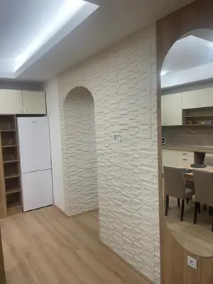 a kitchen and dining room with a white brick wall at Apartman Dasha in Brzeće