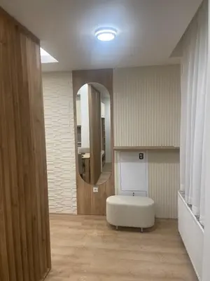 a bathroom with a white ottoman and a mirror at Apartman Dasha in Brzeće