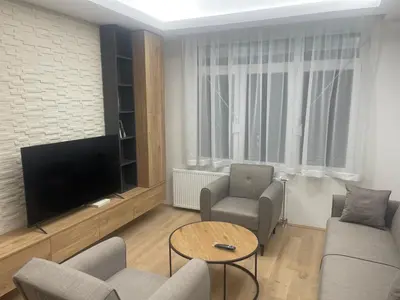 a living room with a television and a couch and chairs at Apartman Dasha in Brzeće