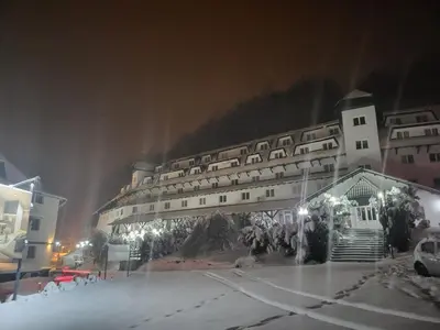 a large building in the snow at night at Apartman Dasha in Brzeće