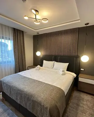 a bedroom with a large bed with white sheets at Mountain Paradise Ski In & Out - Vila Golija Kopaonik in Kopaonik