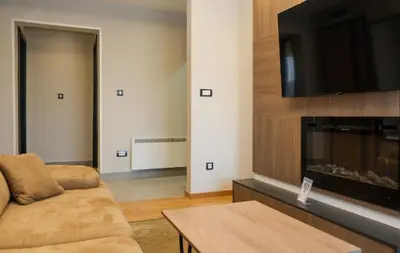 a living room with a couch and a flat screen tv at Mountain Paradise Ski In & Out - Vila Golija Kopaonik in Kopaonik