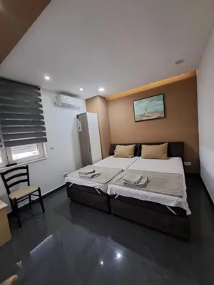 a bedroom with a large bed and a chair at Lena lux in Jagodina