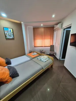 a bedroom with a large bed and a table at Lena lux in Jagodina