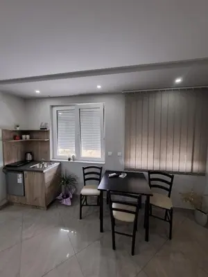 a kitchen with a table and chairs and a sink at Lena lux in Jagodina