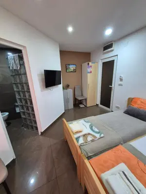 a room with two beds and a flat screen tv at Lena lux in Jagodina