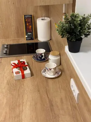 a table with two cups and a gift on a counter at Jokica apartmani in Paraćin