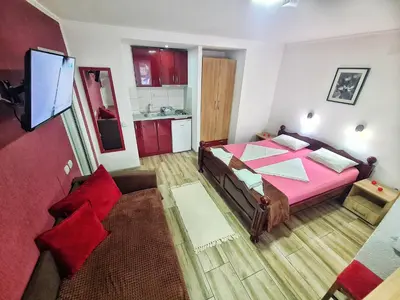a bedroom with a pink bed and a couch at Vila Aleksandra 2 Studio 3 in Soko Banja