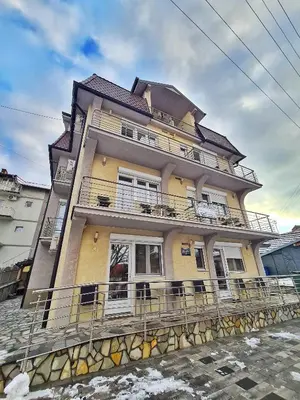 a large yellow building with balconies on a street at Vila Aleksandra 2 Studio 3 in Soko Banja