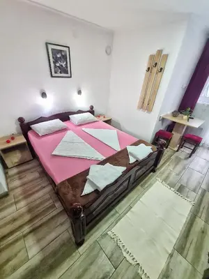 a bedroom with a large bed with a pink blanket at Vila Aleksandra 2 Studio 3 in Soko Banja