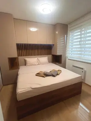 a bedroom with a large bed with towels on it at Happiness Apartman in Vrnjci