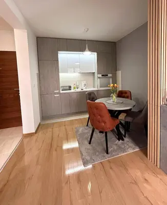 a kitchen and dining room with a table and chairs at Happiness Apartman in Vrnjci