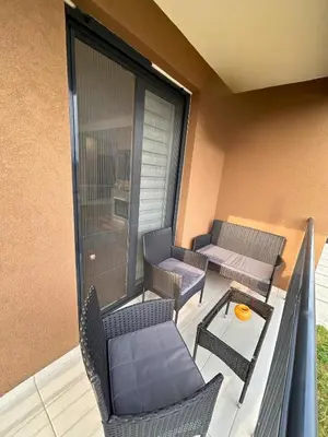 a balcony with two chairs and a table and a table at Happiness Apartman in Vrnjci