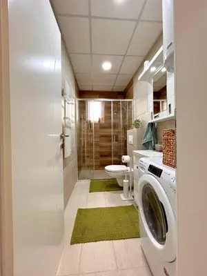 a bathroom with a washing machine and a toilet at Happiness Apartman in Vrnjci