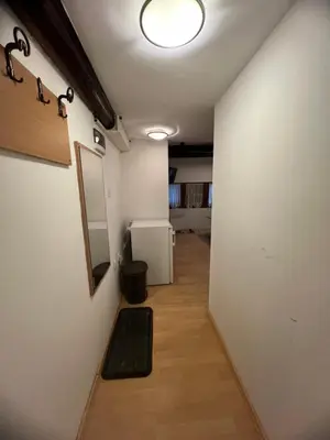 a hallway with a white wall and a refrigerator at Centar kop in Kopaonik