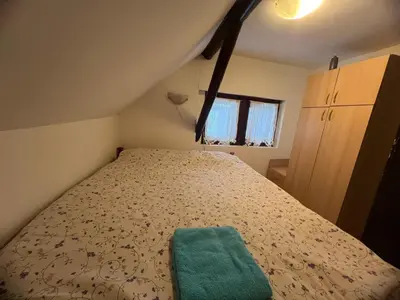 a small bedroom with a bed with a green pillow at Centar kop in Kopaonik
