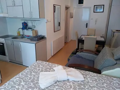 a room with a kitchen and a table with a towel at Smeštaj Vesna in Soko Banja