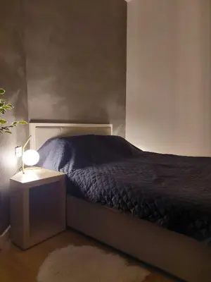 a bedroom with a bed and a night stand with a lamp at Zepterme Apartman 012 in Vrnjačka Banja