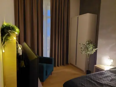 a bedroom with a bed and a tv and a window at Zepterme Apartman 012 in Vrnjačka Banja