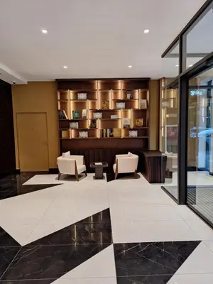 a lobby with two chairs and a book shelf at Zepterme Apartman 012 in Vrnjačka Banja