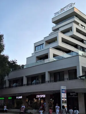 a building with people walking in front of it at Zepterme Apartman 012 in Vrnjačka Banja