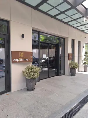 an office building with glass doors and potted plants at Zepterme Apartman 012 in Vrnjačka Banja