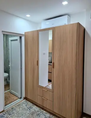 a bathroom with a wooden cabinet with a mirror at Apartman Vesna in Leskovac