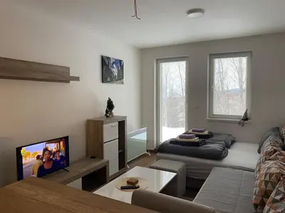 a living room with a couch and a flat screen tv at Apartment Treska Kop in Kopaonik