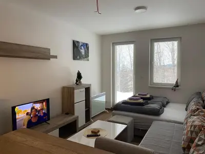 a living room with a couch and a flat screen tv at Apartment Treska Kop in Kopaonik