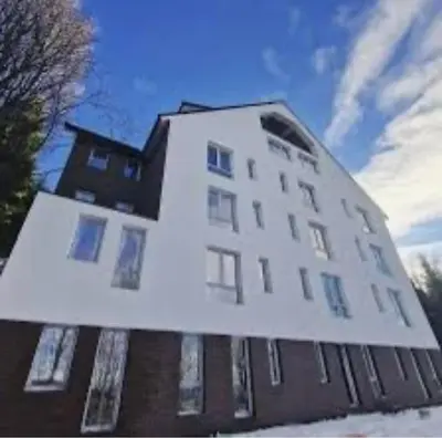 a large white building with snow on the ground at Apartment Treska Kop in Kopaonik