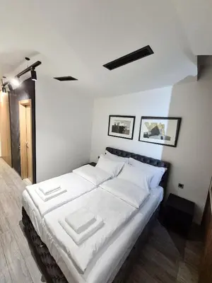 a bedroom with a large bed with white sheets at Fine apartments Nis in Niš