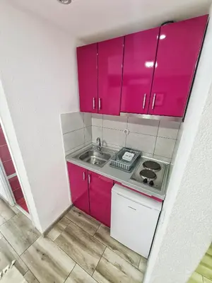 a small kitchen with pink cabinets and a sink at Vila Aleksandra 2 Studio 11 in Soko Banja