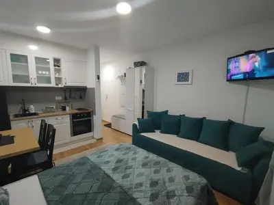 a living room with a couch and a kitchen at Sofika in Vrnjačka Banja