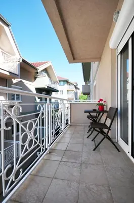 a balcony with chairs and tables on a building at Apartman Cvetkovic in Vrnjačka Banja