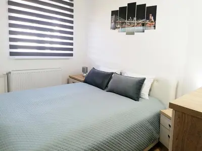 a bedroom with a bed with blue pillows at Apartman Cvetkovic in Vrnjačka Banja
