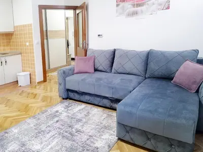 a blue couch in a living room with purple pillows at Apartman Cvetkovic in Vrnjačka Banja