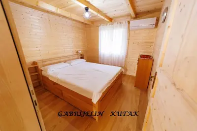 a small bedroom with a bed in a wooden room at Gabrielin kutak in Mužinac