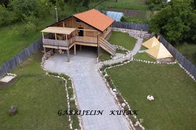 a small wooden cabin in a yard with rocks at Gabrielin kutak in Mužinac