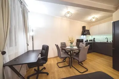 a dining room and kitchen with a table and chairs at Luka's apartment in Pirot