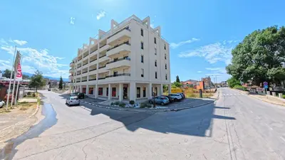 a large white building on the side of a street at In lux spa apartman 2 in Vrnjačka Banja