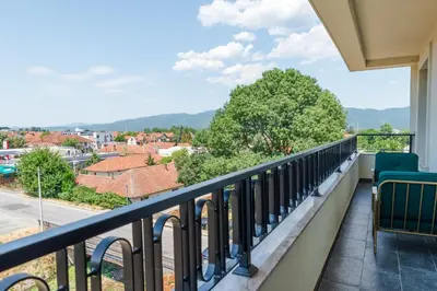 a balcony with chairs and a view of a city at In lux spa apartman 2 in Vrnjačka Banja