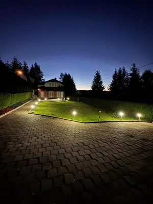 a house with lights on a lawn at night at Vlasina Nature Escape in Lujinska Mala