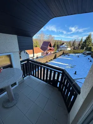 a balcony with a table and a view of a river at Vlasina Nature Escape in Lujinska Mala