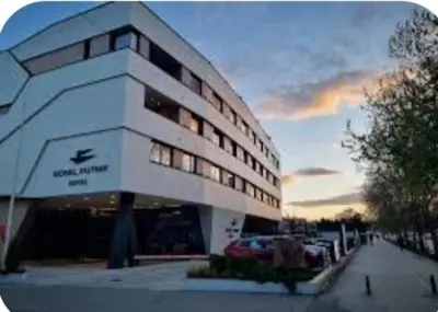 a large white building with cars parked in front of it at Janković in Vranje