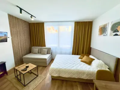 a bedroom with a bed and a couch and a table at Coco Kop studio in Kopaonik
