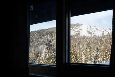a window with a view of a snow covered mountain at Konaci Brvenik Suites in Kopaonik