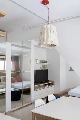 a white living room with a tv and a table at Konaci Brvenik Suites in Kopaonik